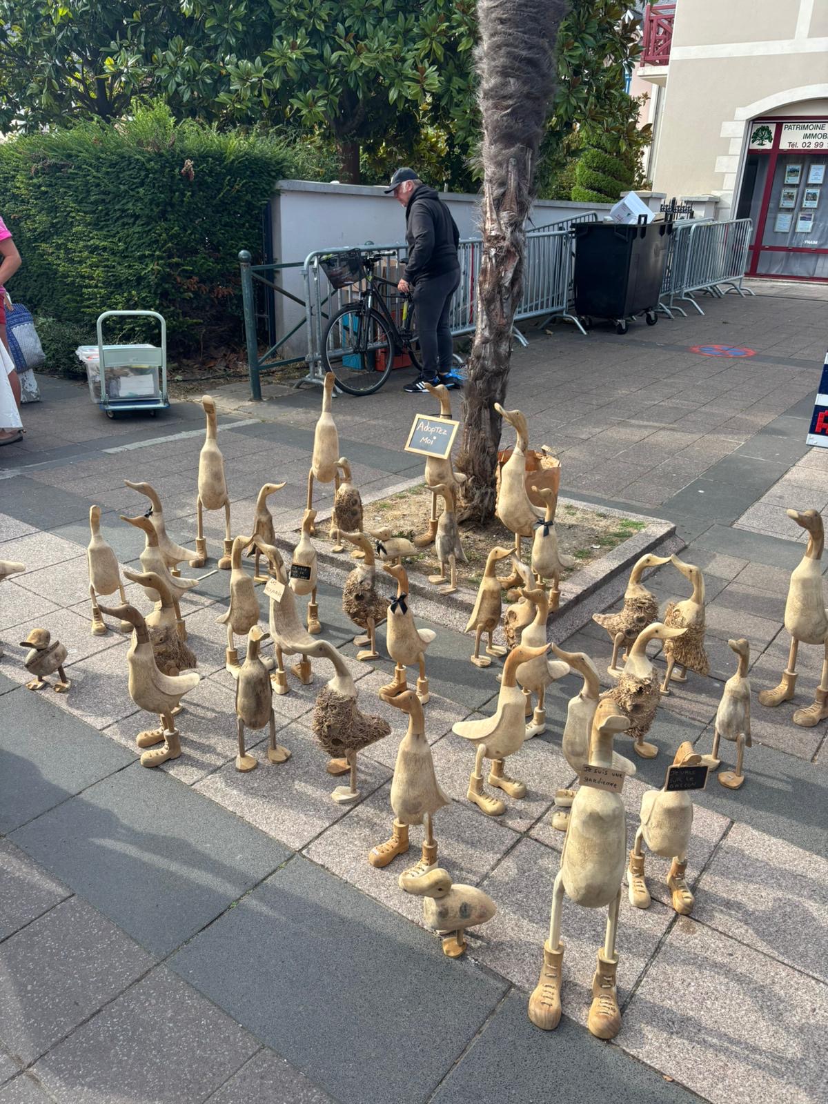 Stand de canards en bois sculptés alignés sur un marché artisanal